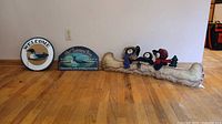 Group shot of round Welcome sign, Looney Bin sign and felt canoe bears