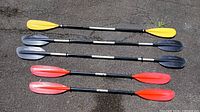 All five kayak paddles laid out showing full length and blade colors