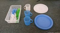 Overview of entire lot: plates, cups, utensils in bin