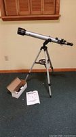 Full telescope mounted on tripod with accessory box and manual
