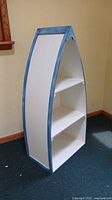 Full view of white canoe bookcase showing shape and size