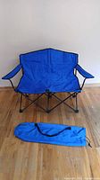 Wide view of unfolded double camping chair and carry bag