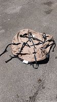 Top view of collapsed brown rooftop cargo bag with straps visible