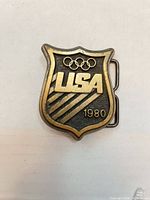 Front view of brass belt buckle showing USA Olympic design