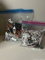 Two clear resealable bags containing assorted costume jewelry