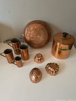 Group shot: saucepan, four measuring cups, three molds, flour canister
