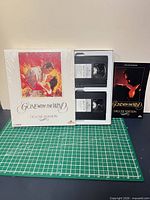 Front view of sealed boxed set with artwork, two tapes and booklet displayed