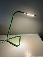 Side view of green IKEA Harte desk lamp illuminated