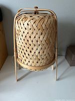 Front view of woven bamboo table lamp on legs