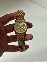 Front view of gold-tone Michael Kors watch in hand