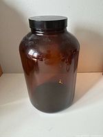 Front view of amber glass bottle with lid