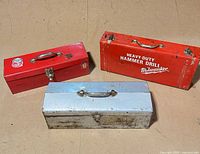 Three metal toolboxes closed showing exterior color and branding