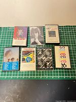 Front view of six cassette cases with album artwork