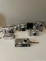Group shot of all six cameras plus charger