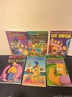 Front covers of all six paperback Simpsons comic books