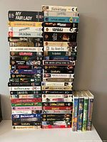Two tall stacks showing quantity and variety of VHS tapes