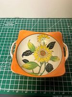 Top view showing hand-painted sunflower design and orange rim
