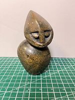 Front view of polished stone sculpture showing face and overall form