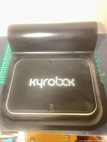 Top view of black kyrobak therapy device showing logo and curved support