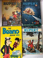 Front covers of four comic annuals showing three Rupert and one Beano 1973