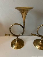 Front view of both brass horn candlesticks