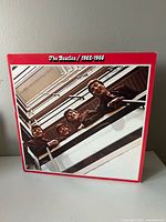 Front cover showing red border and balcony photo of band