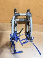 Front view of folded rack showing frame, cradles and straps