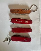 Front view of four pocketknives showing handles and logos