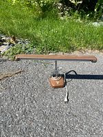 Full view of brown and chrome fluorescent desk lamp on pavement