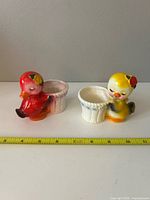 Both ceramic chick planters side by side with measuring tape showing approx 4 in length