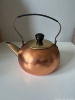 Front view showing copper body, brass spout, lid and handle