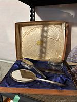 Full dresser set displayed inside original box with blue satin lining and cream-colored silk lid lining