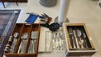 Full view of flatware organized in wooden tray, including additional spoons, paper towel holder, and carrying bag.