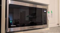 Full front view of stainless steel microwave showing exterior and brand logo