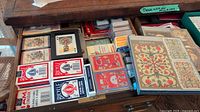 Photo showing drawer with multiple decks of playing cards including Bicycle and artistic decks