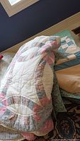 Folded view of stacked quilt showing double wedding ring arcs in pastel floral and gingham prints