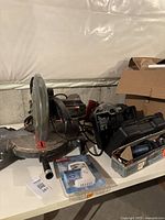 Photo of Craftsman miter saw with blade guard and dust collection port, showing some dust and wear.