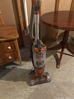 Full view of the Rocket Professional upright vacuum cleaner showing handle, hose, dust canister, and base head