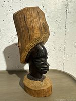 Front view of the natural wood carved bust showing detailed facial features and headdress.