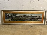 Full view of the framed decorative textile fabric artwork showing a panoramic nature scene with a wooden and metal frame.