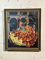 Framed tapestry art piece visual showing Spanish flamenco dancer with vibrant ruffled dress and background architectural elements.