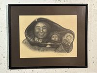 Front view of the framed charcoal drawing showing a person with a child wrapped in furs.