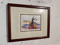 Framed artwork titled "Mother and Our Future" featuring an Indigenous figure, shown against a white wall.