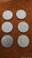 Six 1978 US one dollar coins showing obverse sides with Eisenhower's profile on a brown background.
