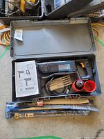 Open Bosch carrying case showing rotary hammer drill model 11224 VSR, drill bit set, red holders, and instruction manual.