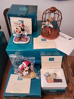 Group of four Disney ceramic figurines with teal boxes and certificates