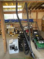 Wide shot in workshop showing boxed Everbilt pump next to Genie vacuum