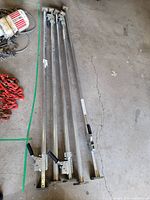 Top view of 5 load bars lined up side by side, showing length and ratchet mechanism handles