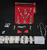 Full view of the collection showing wristwatches at the bottom and various necklaces, earrings, and bracelets on top.