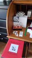 Overall lot arranged on wooden desk showing three crystal pieces, boxes, book and stand